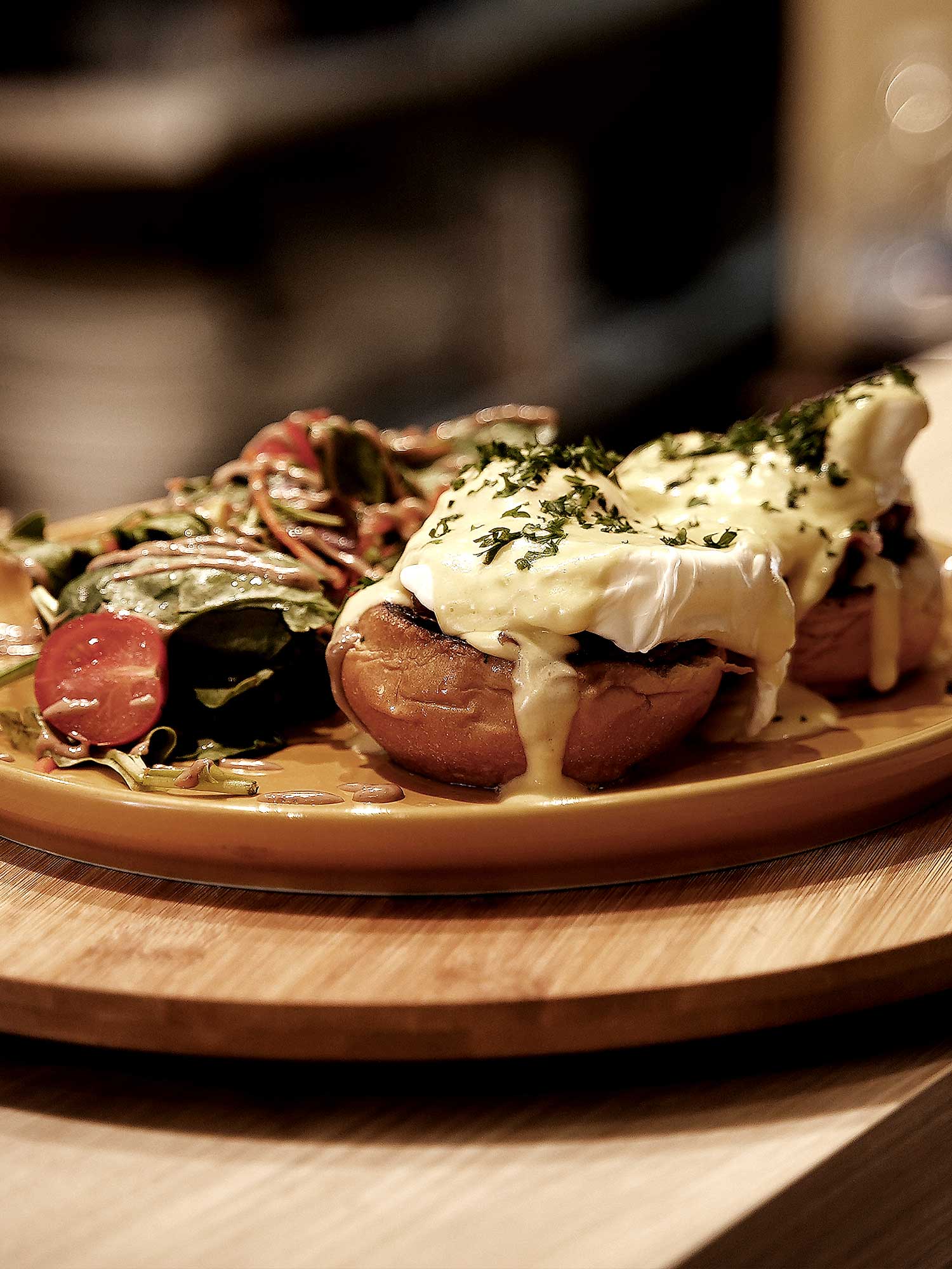 Le Mythe - English bun, bacon fumé, oignons rouges, oeuf poché nappée de sauce hollandaise, servis avec salade