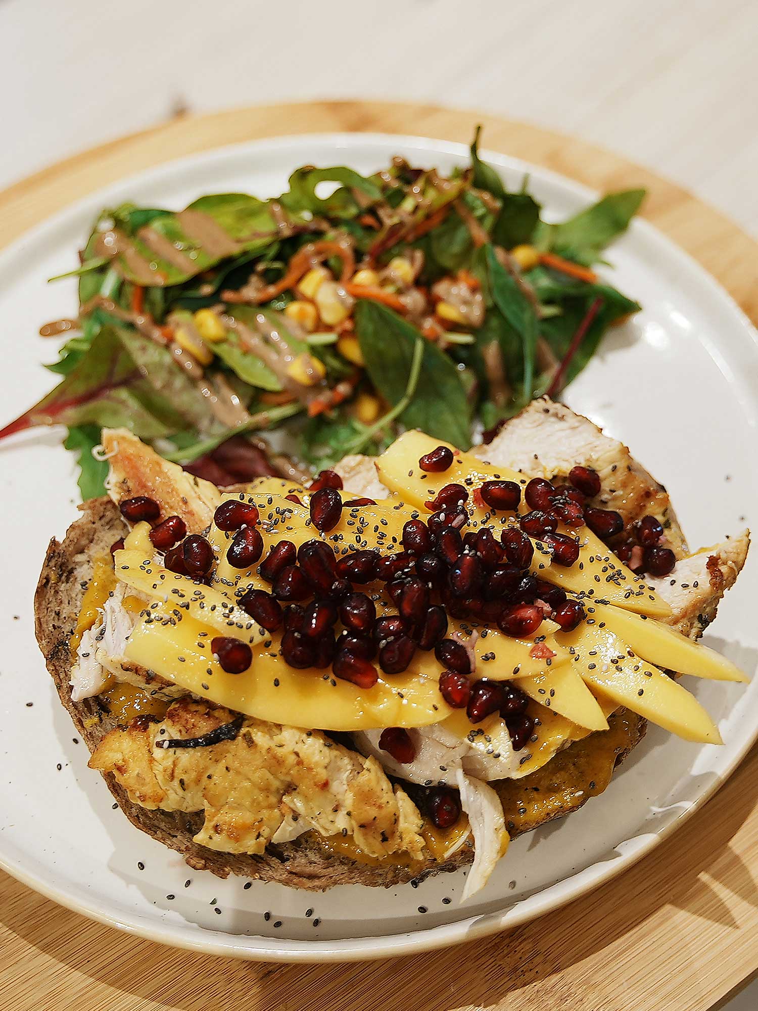 Mango-Chicken - Pain au levain, crème curry mangue, poulet mariné, lamelles de mangue, grenade, oignons rouges, servis avec salade