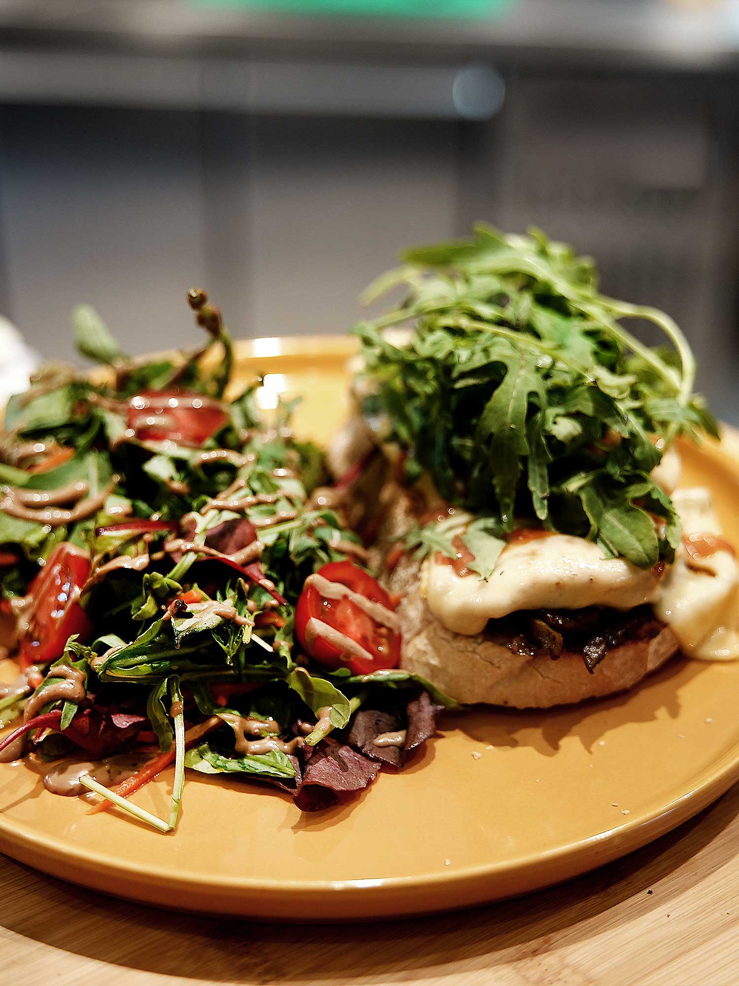 Spicy chicken - Pain au levain, poulet épicé, guacamole, oignons rouges, tomates cerise, roquette, Parmesan, servie avec salade