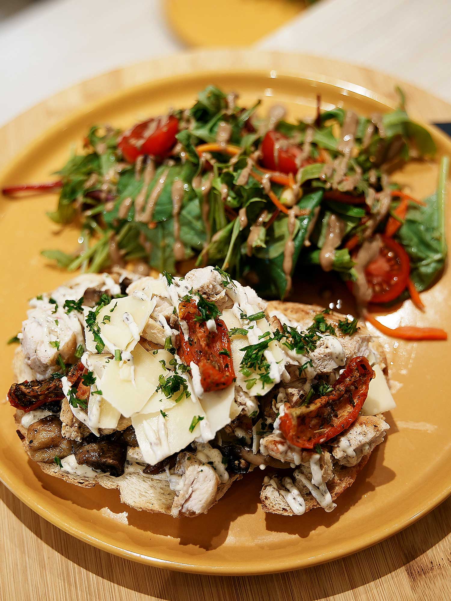 Tartufata - Pain au levain, crème truffe, poulet grillé, champignons, tomates séchées, Parmesan, servis avec salade
